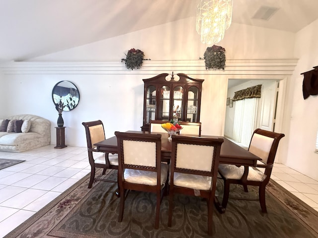 dining space featuring tile patterned floors, a chandelier, and vaulted ceiling