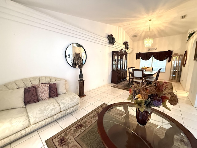 living room with lofted ceiling, light tile patterned floors, and an inviting chandelier