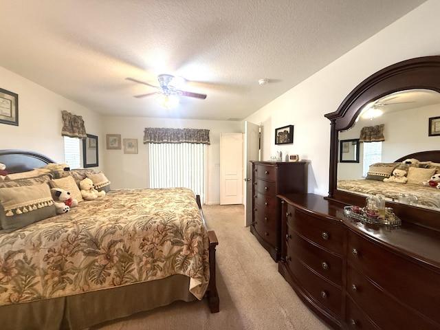 bedroom featuring ceiling fan, light carpet, and a textured ceiling