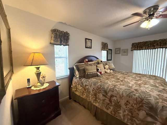 carpeted bedroom with multiple windows and ceiling fan