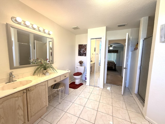 bathroom with vanity, toilet, a textured ceiling, and walk in shower