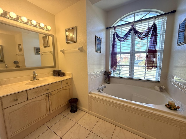 bathroom featuring plenty of natural light, tiled bath, and vanity