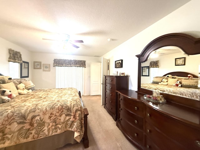 carpeted bedroom featuring ceiling fan and a textured ceiling