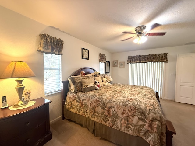 bedroom with ceiling fan, carpet flooring, and a textured ceiling