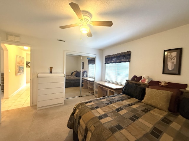 carpeted bedroom featuring a closet and ceiling fan