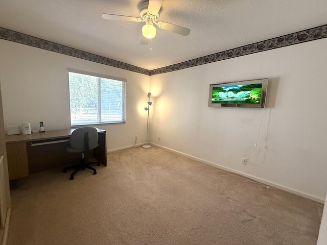 carpeted home office featuring ceiling fan and a textured ceiling