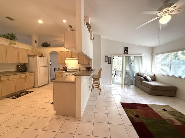 kitchen with a breakfast bar area, light brown cabinetry, white appliances, and kitchen peninsula