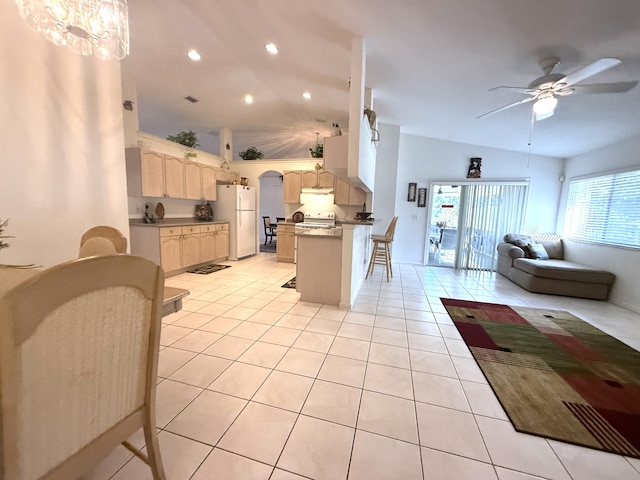 kitchen featuring a breakfast bar area, stainless steel range with electric stovetop, light tile patterned floors, white refrigerator, and ceiling fan