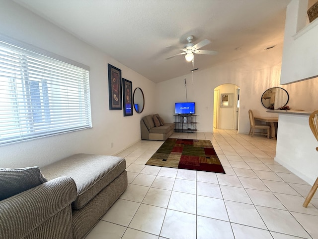 living room with light tile patterned flooring, vaulted ceiling, a textured ceiling, and ceiling fan