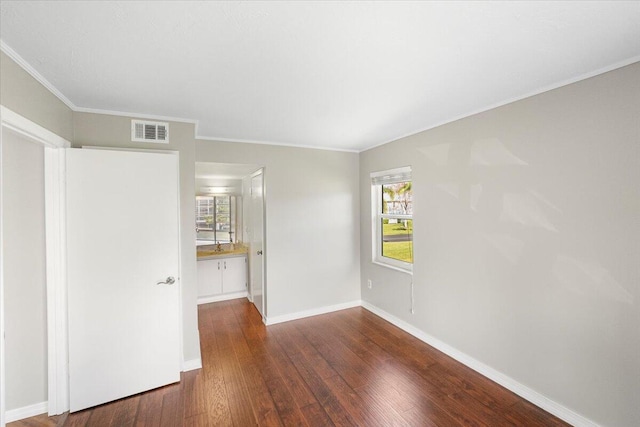 empty room with crown molding and dark hardwood / wood-style floors