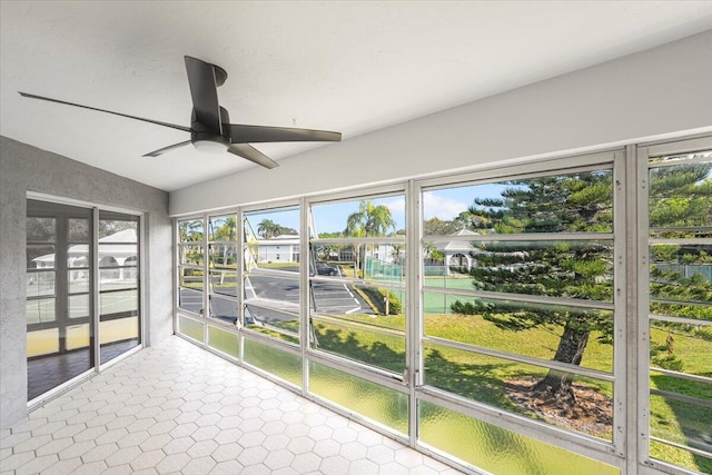 unfurnished sunroom featuring a healthy amount of sunlight, vaulted ceiling, and ceiling fan