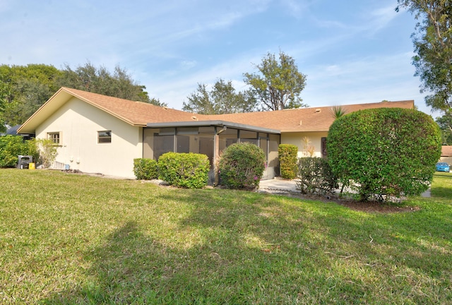 back of property featuring a yard and a sunroom