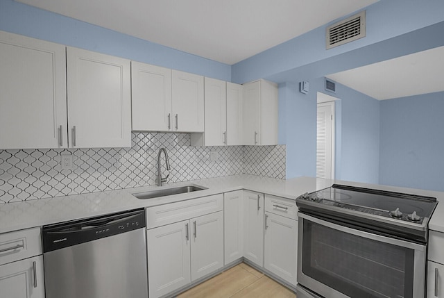 kitchen with white cabinetry, stainless steel appliances, sink, and tasteful backsplash