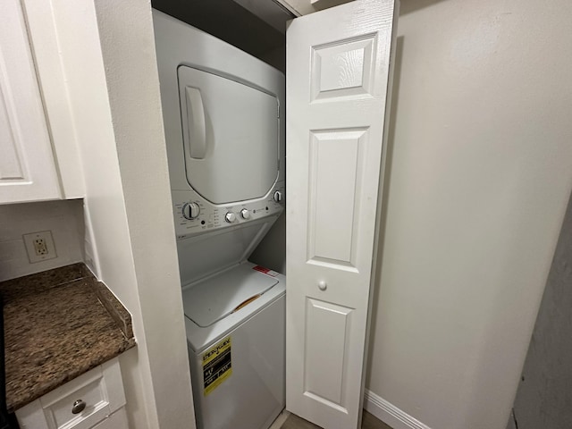 laundry area featuring stacked washer / drying machine