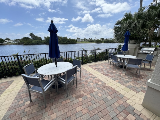 view of patio / terrace with a water view and a grill