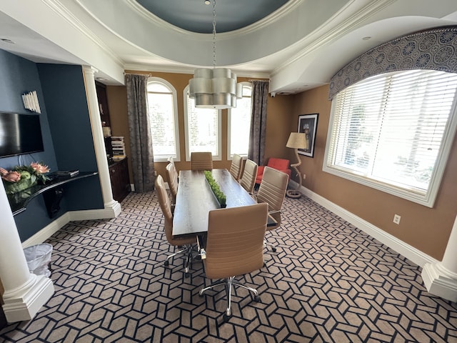 dining area with carpet floors, ornamental molding, a raised ceiling, and ornate columns