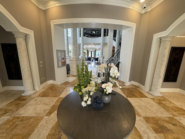 foyer featuring ornate columns and crown molding