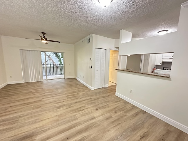 unfurnished living room featuring ceiling fan, light hardwood / wood-style floors, and a textured ceiling