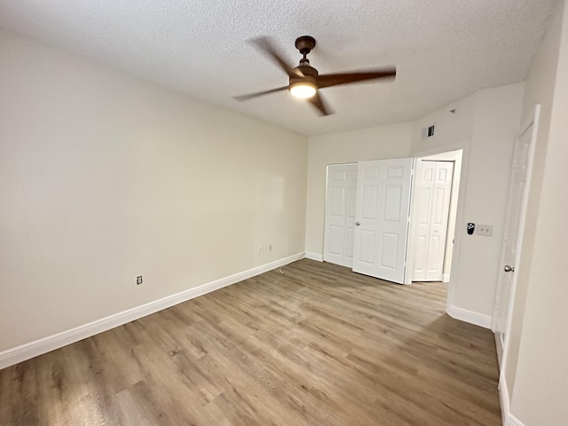 unfurnished bedroom with a closet, ceiling fan, hardwood / wood-style floors, and a textured ceiling