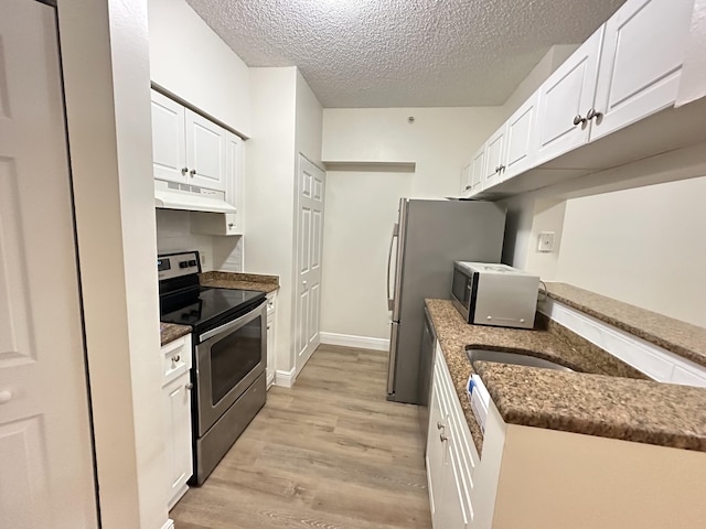 kitchen featuring a textured ceiling, light hardwood / wood-style flooring, white cabinets, and appliances with stainless steel finishes