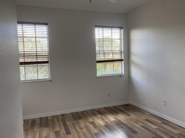 empty room with ceiling fan and dark hardwood / wood-style floors