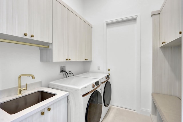 washroom with cabinets, sink, and washing machine and clothes dryer