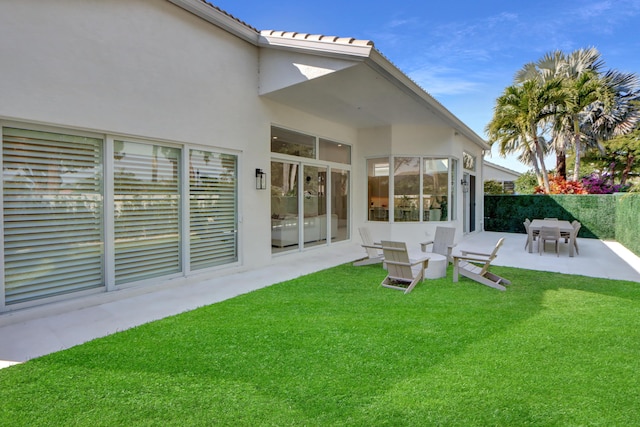 rear view of property featuring a yard and a patio