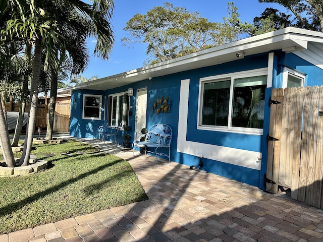 view of front of house with a patio and a front yard