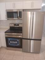 kitchen featuring white cabinetry, light tile patterned floors, and stainless steel appliances