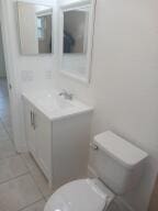 bathroom with tile patterned flooring, vanity, and toilet