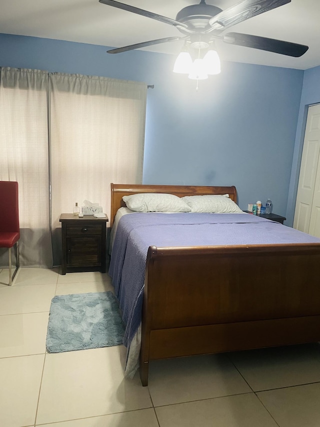 tiled bedroom featuring ceiling fan