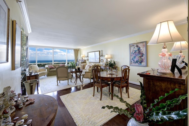 dining space with crown molding, a wall of windows, and hardwood / wood-style flooring