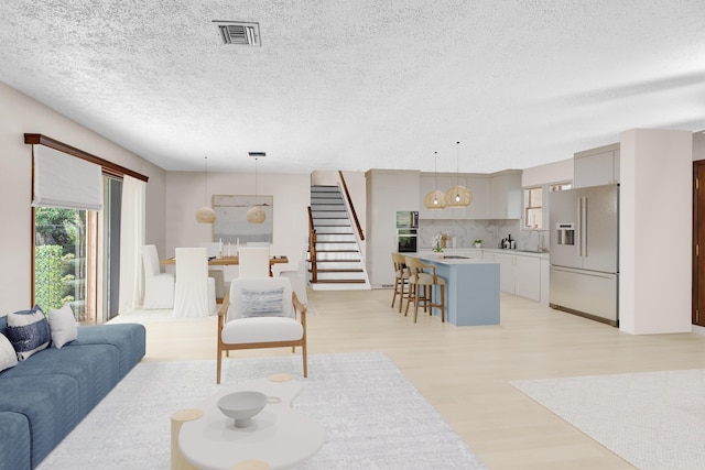 living room featuring light hardwood / wood-style flooring and a textured ceiling