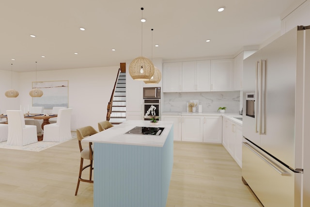 kitchen featuring decorative light fixtures, tasteful backsplash, white cabinets, light hardwood / wood-style floors, and black appliances