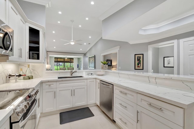 kitchen with white cabinetry, crown molding, light stone counters, kitchen peninsula, and stainless steel appliances