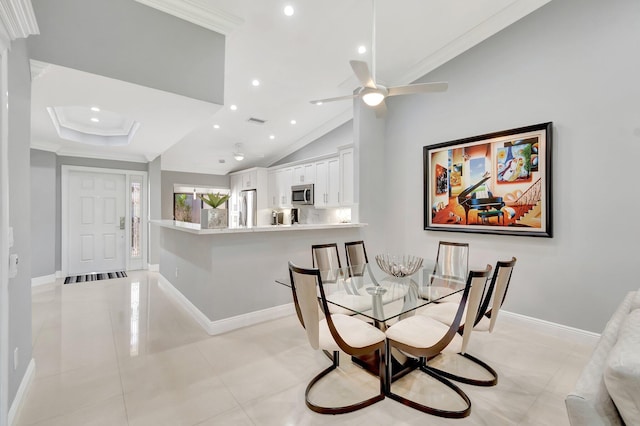 dining room with ornamental molding, vaulted ceiling, and light tile patterned flooring