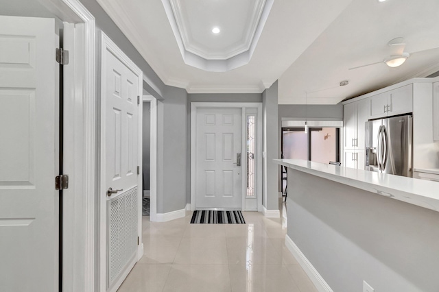 interior space with light tile patterned floors, crown molding, and a raised ceiling