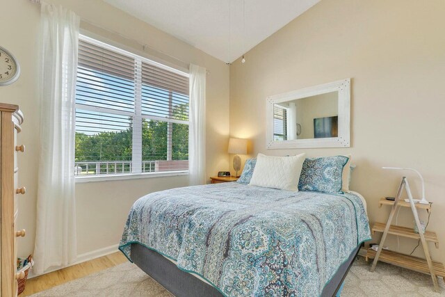 bedroom with vaulted ceiling, ceiling fan, and light hardwood / wood-style flooring