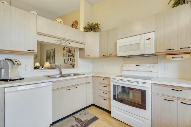 kitchen with sink, light brown cabinets, white appliances, and light hardwood / wood-style flooring