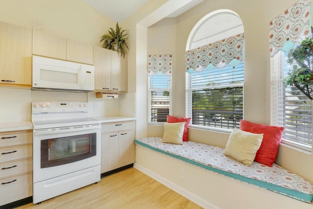 kitchen with light brown cabinets, white appliances, and light hardwood / wood-style flooring