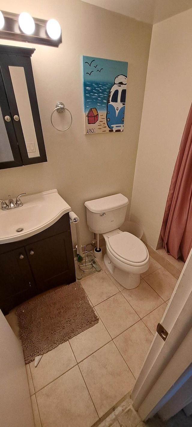 bathroom featuring tile patterned floors, toilet, and vanity