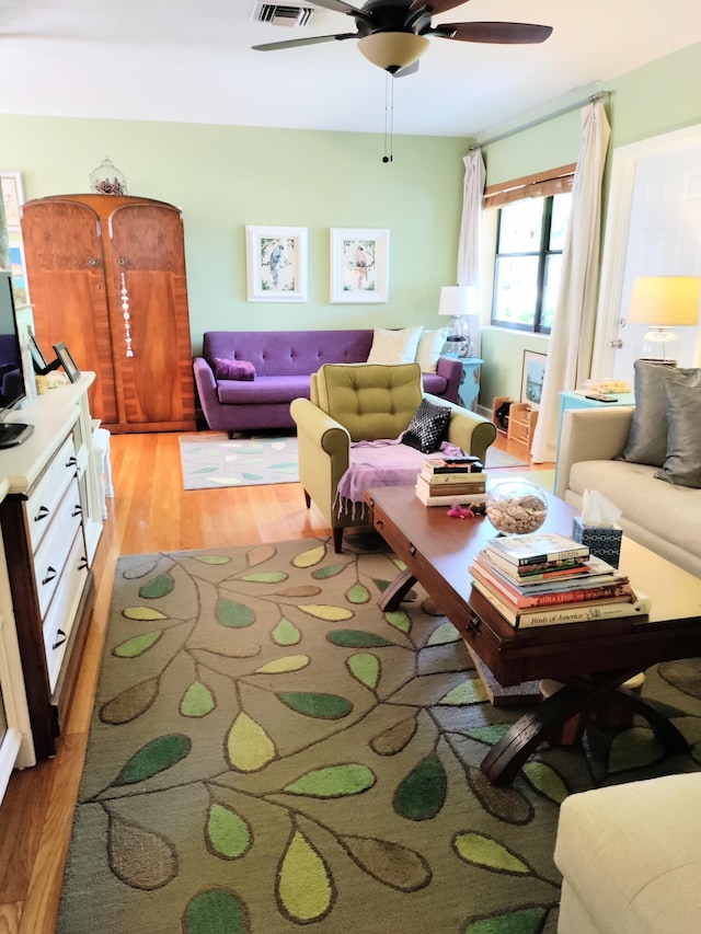 living room featuring ceiling fan and light hardwood / wood-style flooring