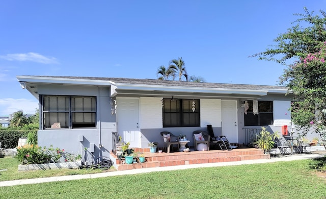 single story home with a porch and a front lawn