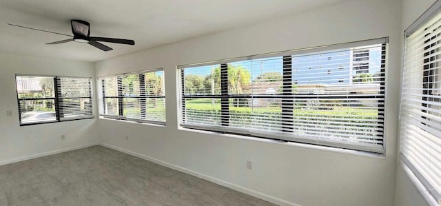 unfurnished sunroom featuring a wealth of natural light and ceiling fan