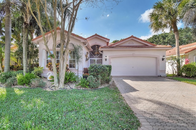 mediterranean / spanish house with a garage and a front lawn