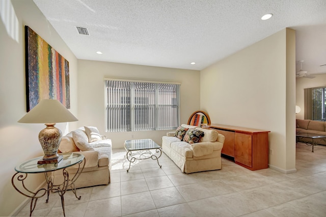 sitting room featuring ceiling fan, a textured ceiling, and light tile patterned flooring