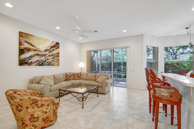 living room with light tile patterned flooring and ceiling fan with notable chandelier