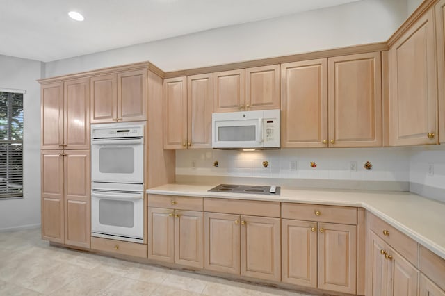 kitchen with tasteful backsplash, white appliances, and light brown cabinetry