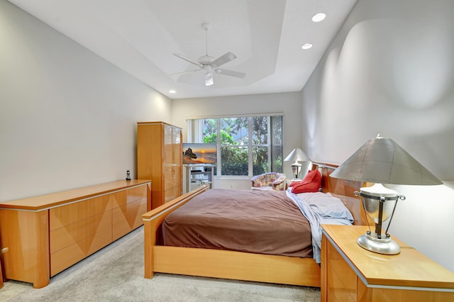 carpeted bedroom featuring a raised ceiling and ceiling fan