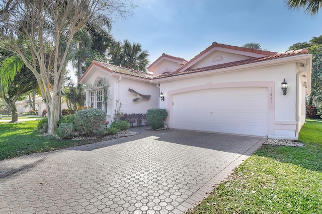 mediterranean / spanish-style home featuring a garage and a front lawn